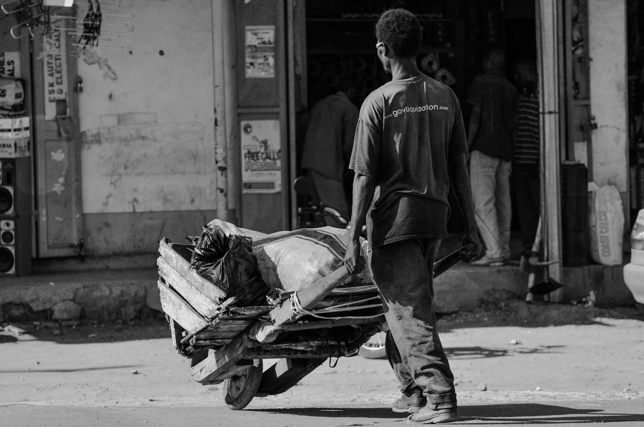 A man pushing a cart down a city street