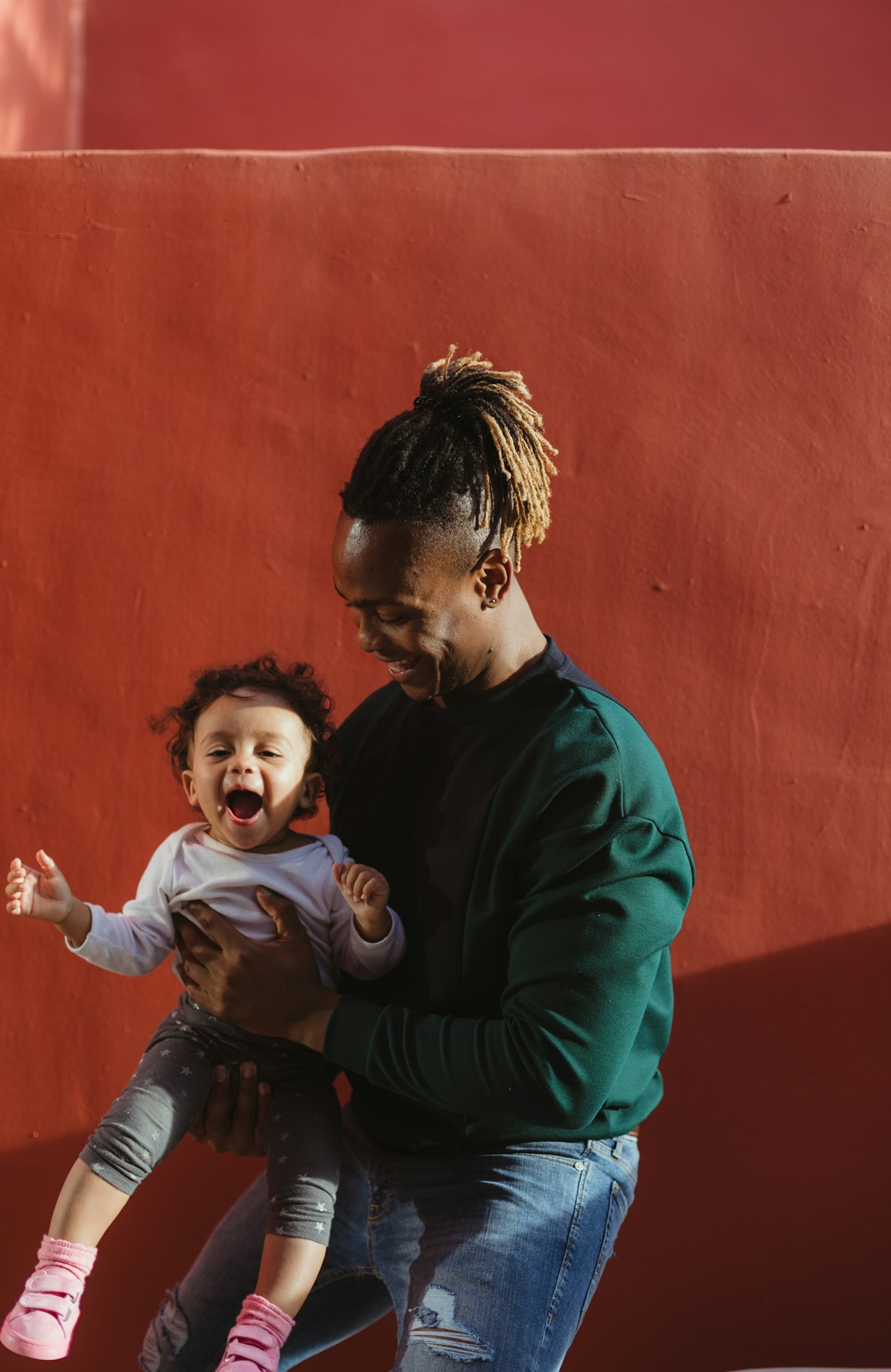 A father smiling and playing with his young child