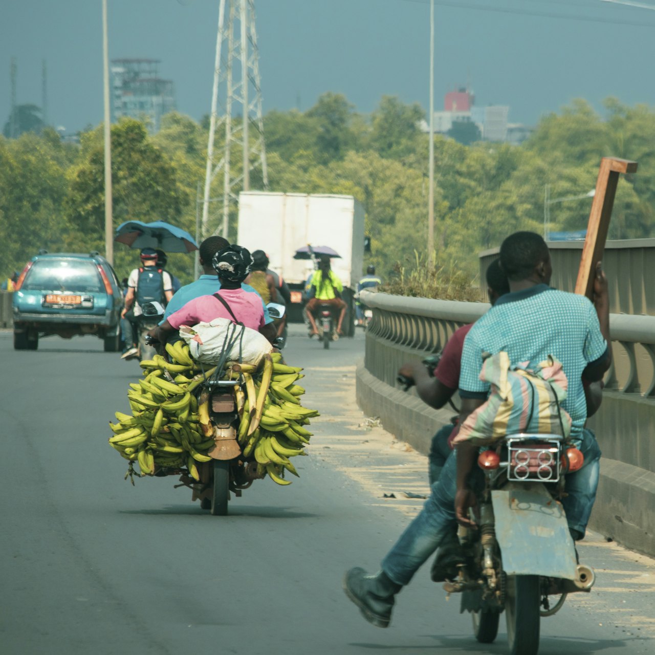 A motorbike carrying a load of bananas across a bridge