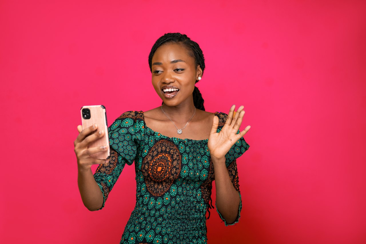 A smiling woman holding her phone