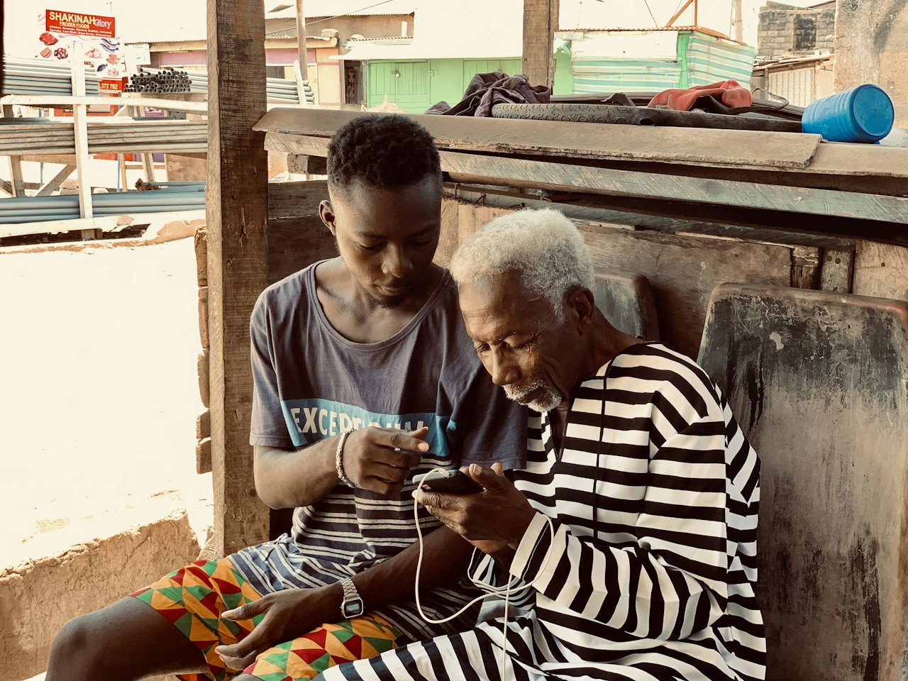 A young man and an elderly woman looking at a phone together